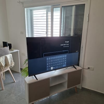 טלוויזיה על מזנון מול חלון עם תריסים