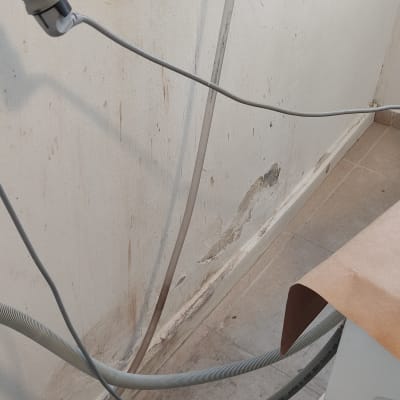 קיר עם כתמי רטיבות ותיקוני צבע