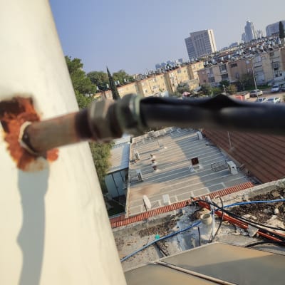 צינור מחובר לדוד שמש על גג בניין