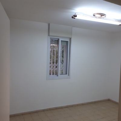 חדר עם קירות צבועים בלבן ותאורה עליונה