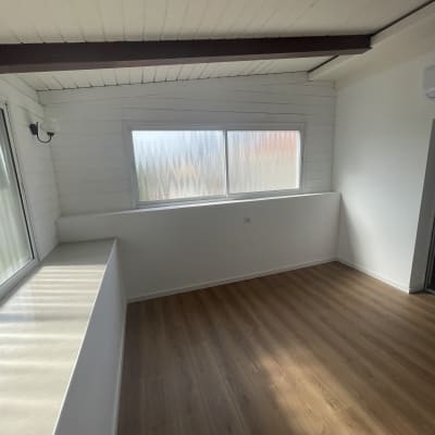 חדר נקי עם רצפת עץ וחלון גדול