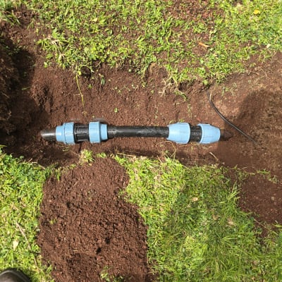 צינור פלסטיק עם מחברים כחולים באדמה