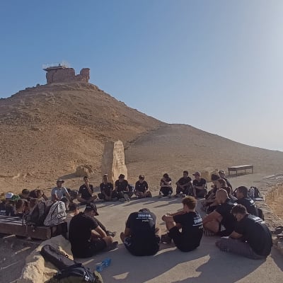 קבוצת אנשים יושבת במעגל במדבר