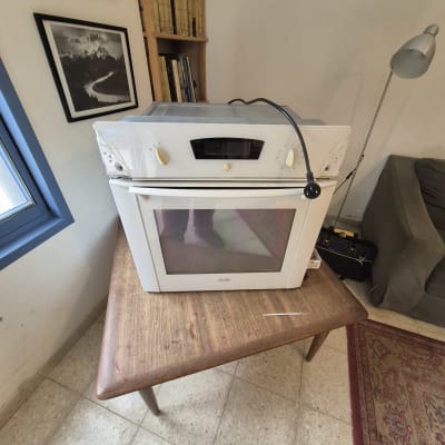 תנור חשמלי לבן על שולחן עץ עם כבל חשמל
