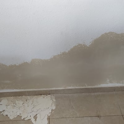 קיר עם צבע מתקלף וכתם לחות