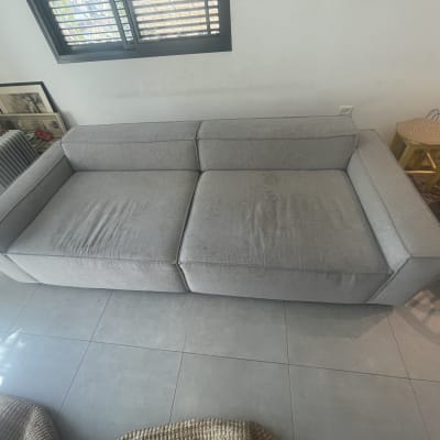 כתמים על ספה אפורה הממתינה לניקוי