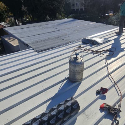 עבודת איטום על גג עם יריעות וכלים מתאימים