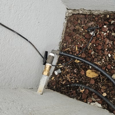 צינור מים עם שסתום ליד קיר בטון