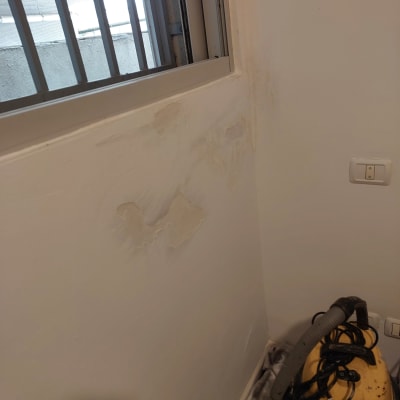 קיר עם סימני רטיבות ליד חלון