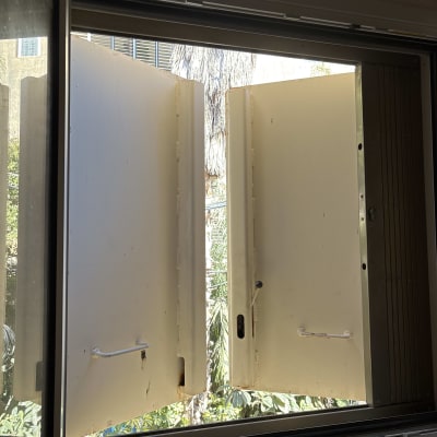 חלון פתוח עם תריסים לבנים