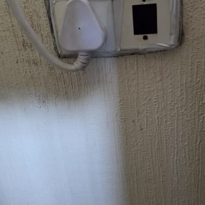 תקע חשמל מחובר לשקע בקיר