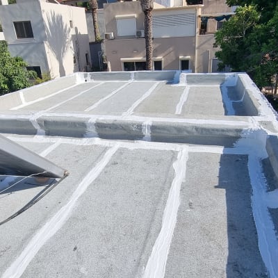 גג אטום עם חומר איטום לבן בין לוחות בטון