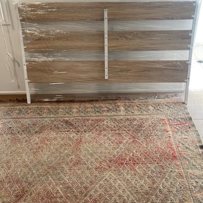 ראש מיטה עטוף בניילון על שטיח צבעוני