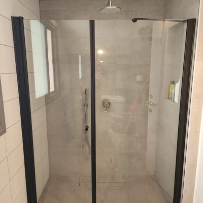 מקלחון זכוכית עם דלתות ומקלחת גשם