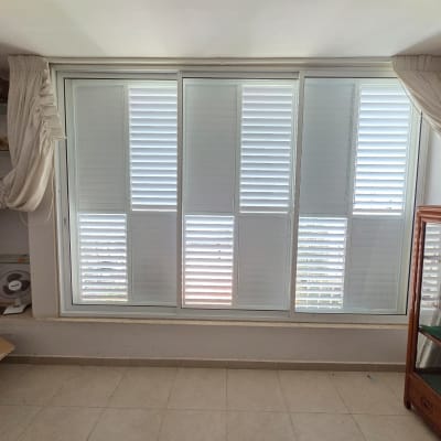 חלון עם תריסי אלומיניום בחדר