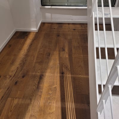 רצפת פרקט עץ כהה ליד מדרגות לבנות