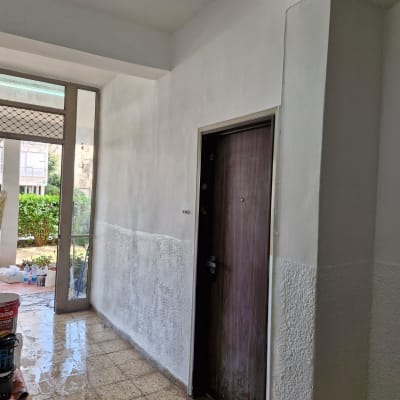 מסדרון עם דלת, קירות צבועים וכלי עבודה.