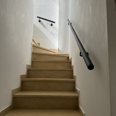 מדרגות עם מעקה מתכת שחור בצדדים