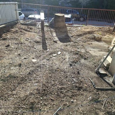 שטח אדמה עם גדם עץ וכלי עבודה לגינון