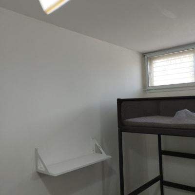 חדר עם קיר צבוע בלבן ומדף מותקן