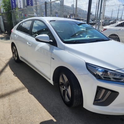 מכונית לבנה חונה עם פנסי חזית גלויים