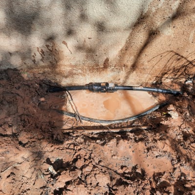 צינור מים שחור עם חיבור במים ובוץ