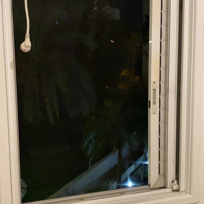 חלון אלומיניום פתוח עם מסגרת לבנה