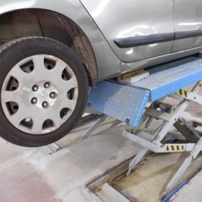 רכב על מעלית הידראולית במוסך לתיקון גוף