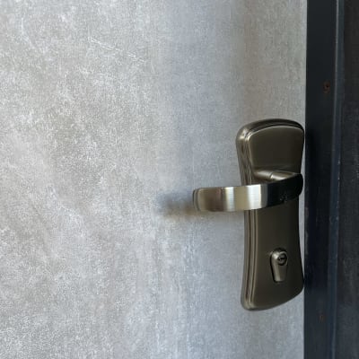 ידית דלת מתכתית על דלת מצופה