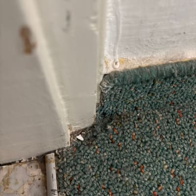 שטיח מלוכלך ליד פינה של קיר