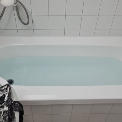 אמבטיה עם מים, ברז ומקלחת יד