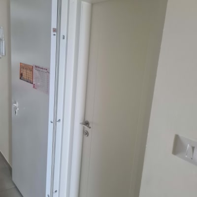 דלת לבנה עם ידית כסופה ומסילה עליונה