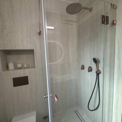 מקלחת מודרנית עם דלת זכוכית וברזים מעוצבים