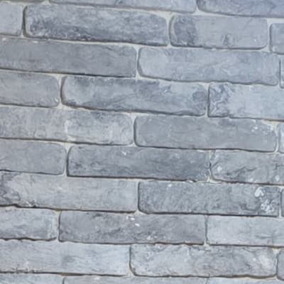 קיר לבנים אפור עם מנורה בתקרה