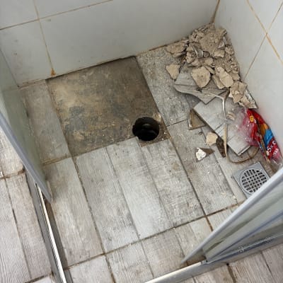 שיפוץ מקלחת עם רצפה שבורה ופסולת