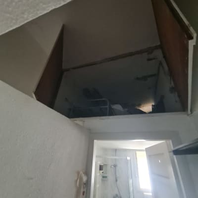 חדר אמבטיה עם דלת פתוחה ותקרה פתוחה