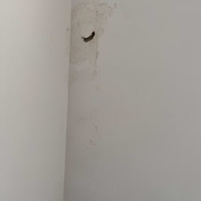 קיר עם קילופי צבע וחור קטן