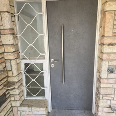 דלת אפורה עם ידית מתכת ארוכה ומנעול