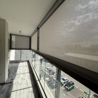 מרפסת עם סוככים שקופים ומעקה זכוכית