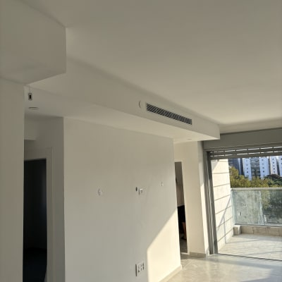 קירות צבועים בלבן בחדר מואר עם מרפסת