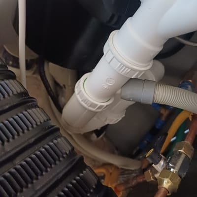 צינור פלסטיק לבן עם מחברים מתחת לכיור