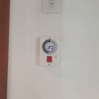 שעון טיימר חשמלי ומתג הפעלה על קיר