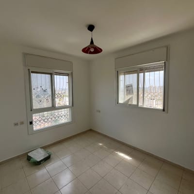 חדר ריק עם חלונות, ריצוף חדש וצבע טרי על הקירות.