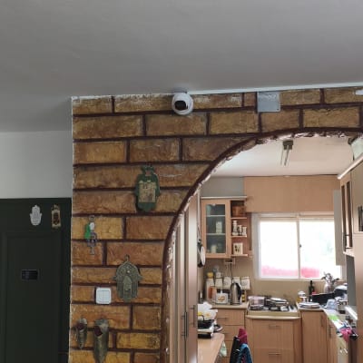 מצלמת אבטחה מותקנת על קיר לבנים במטבח ביתי