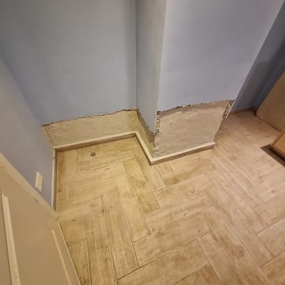 קיר עם טיח מתקלף ליד רצפת עץ