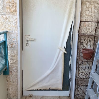 דלת עם ציפוי מתקלף בחלק התחתון