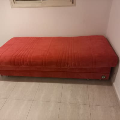 ספה אדומה בחדר עם רצפת אריחים בהירים