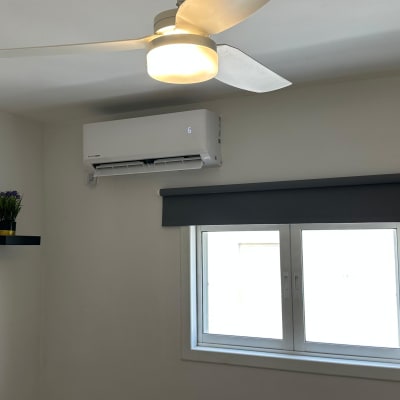 מזגן תלוי על קיר בחדר עם מאוורר תקרה