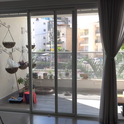 רשת הזזה מותקנת על ויטרינת הזזה ביציאה למרפסת