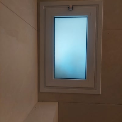 חלון אלומיניום עם זכוכית חלבית על קיר בהיר